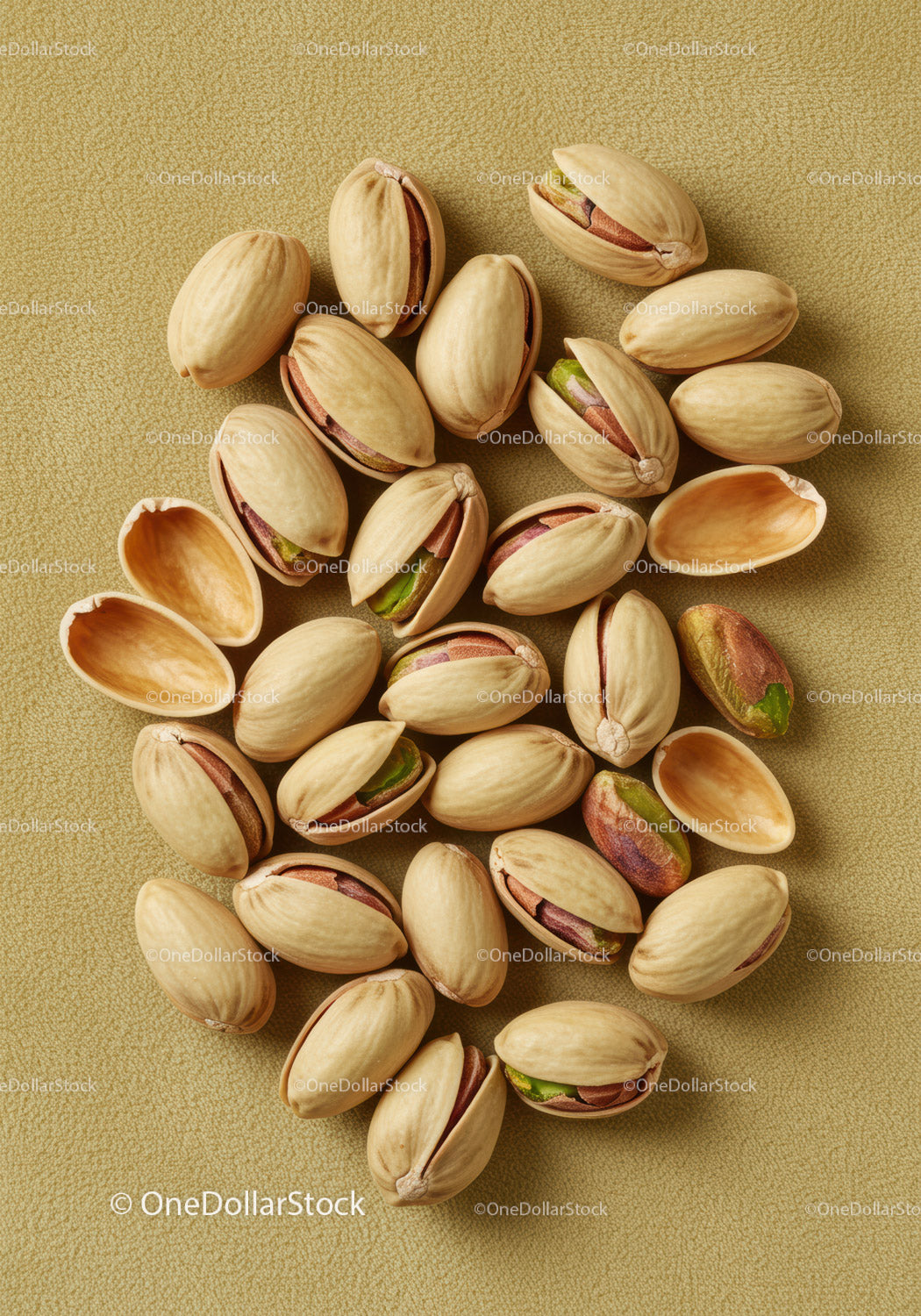 Close up of pistachio nuts with shells on textured surface