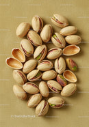 Close up of pistachio nuts with shells on textured surface
