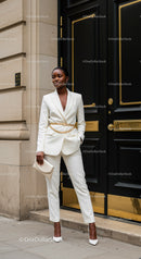 Elegant woman in white suit stands by classic door
