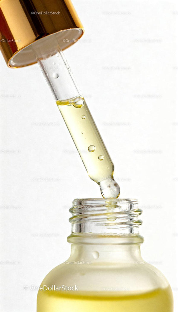 Zbliżenie na złotą pipetę z serum do twarzy z płynem