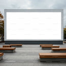 Outdoor urban space with large blank billboard and wooden benches