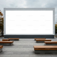 Outdoor urban space with large blank billboard and wooden benches