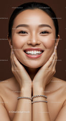 Young Asian woman smiling with hands on face and bracelets