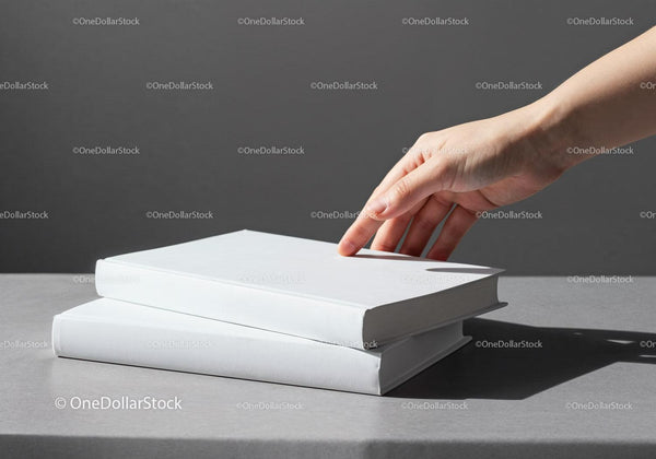 Hand Reaching for Stack of White Hardcover Books JPG Mockup Image