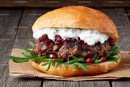 Gourmet Beef Burger with Cheese and Pomegranate on Rustic Wood