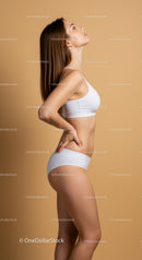Elegant Woman in Fitness Attire Posing Against Minimalistic Background