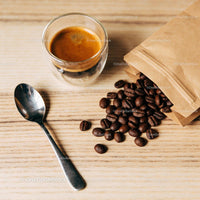Freshly brewed espresso with scattered coffee beans