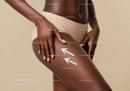 Elegant Dark Skin Woman Touching Thigh in Minimalist Studio Setting