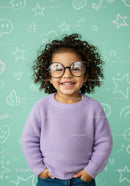 Smiling curly child with big round glasses and cozy sweater