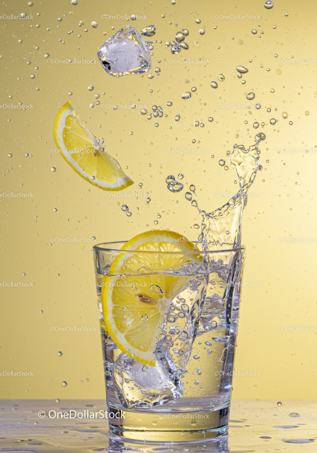 Refreshing lemon and ice splash in clear glass