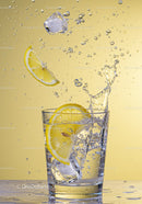 Refreshing lemon and ice splash in clear glass