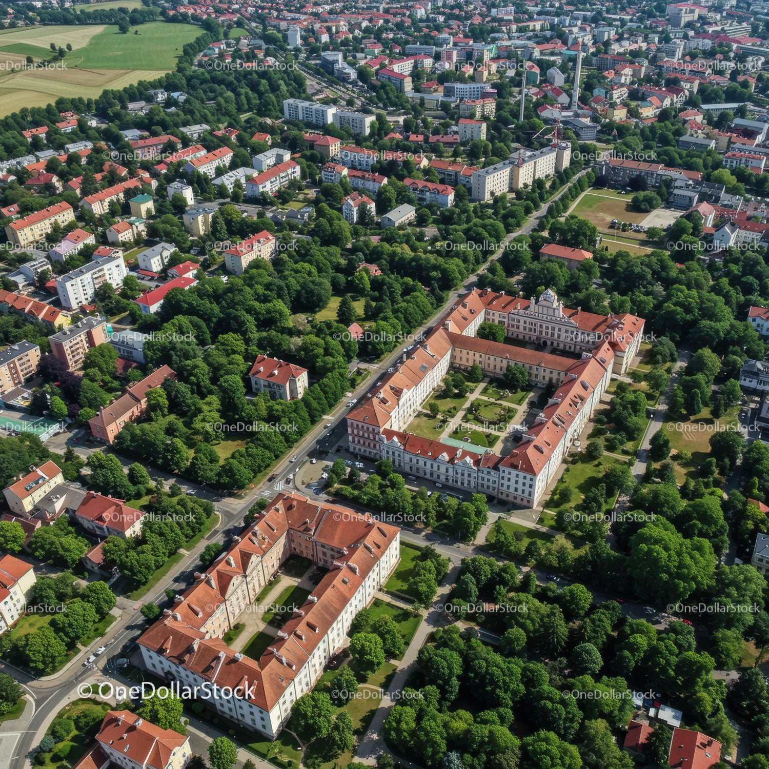 Fotografia lotnicza historycznego kampusu uniwersyteckiego z czerwonymi dachami i zielonymi drzewami