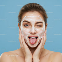 Young Woman with White Facial Mask Relaxing Against Blue Background
