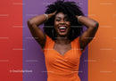 Joyful Woman with Afro Hair in Orange Dress Celebrating Against Colorful Background