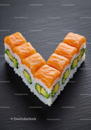 Fresh salmon avocado sushi rolls arranged on black slate