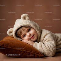 Child resting peacefully in cozy bear hoodie