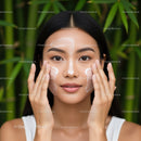 Young Woman Applying Skincare Cream in a Tropical Garden Setting
