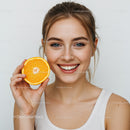 Smiling Woman with Fresh Orange Slice Brightening Her Day