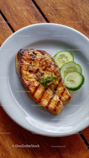 Grilled Salmon with Cucumber Slices on White Plate in Rustic Setting