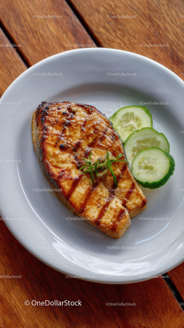 Grilled Salmon with Cucumber Slices on White Plate in Rustic Setting