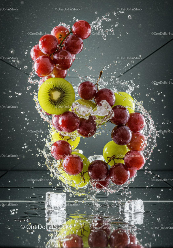 Fresh red and green grapes with kiwi and ice splash