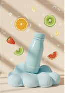 Blue Bottle on Soft Cloud with Floating Fruit Slices