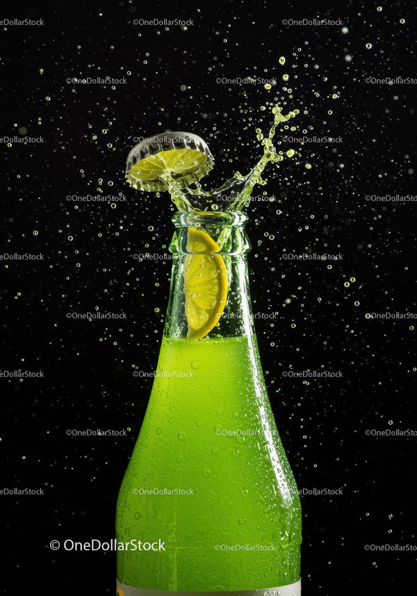 Refreshing lime soda bottle with splashing cap and lemon slice