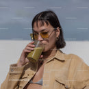 Fashionable Woman Drinking Green Smoothie in Outdoor Setting