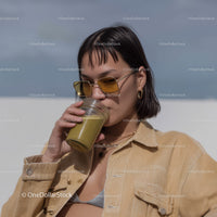 Fashionable Woman Drinking Green Smoothie in Outdoor Setting