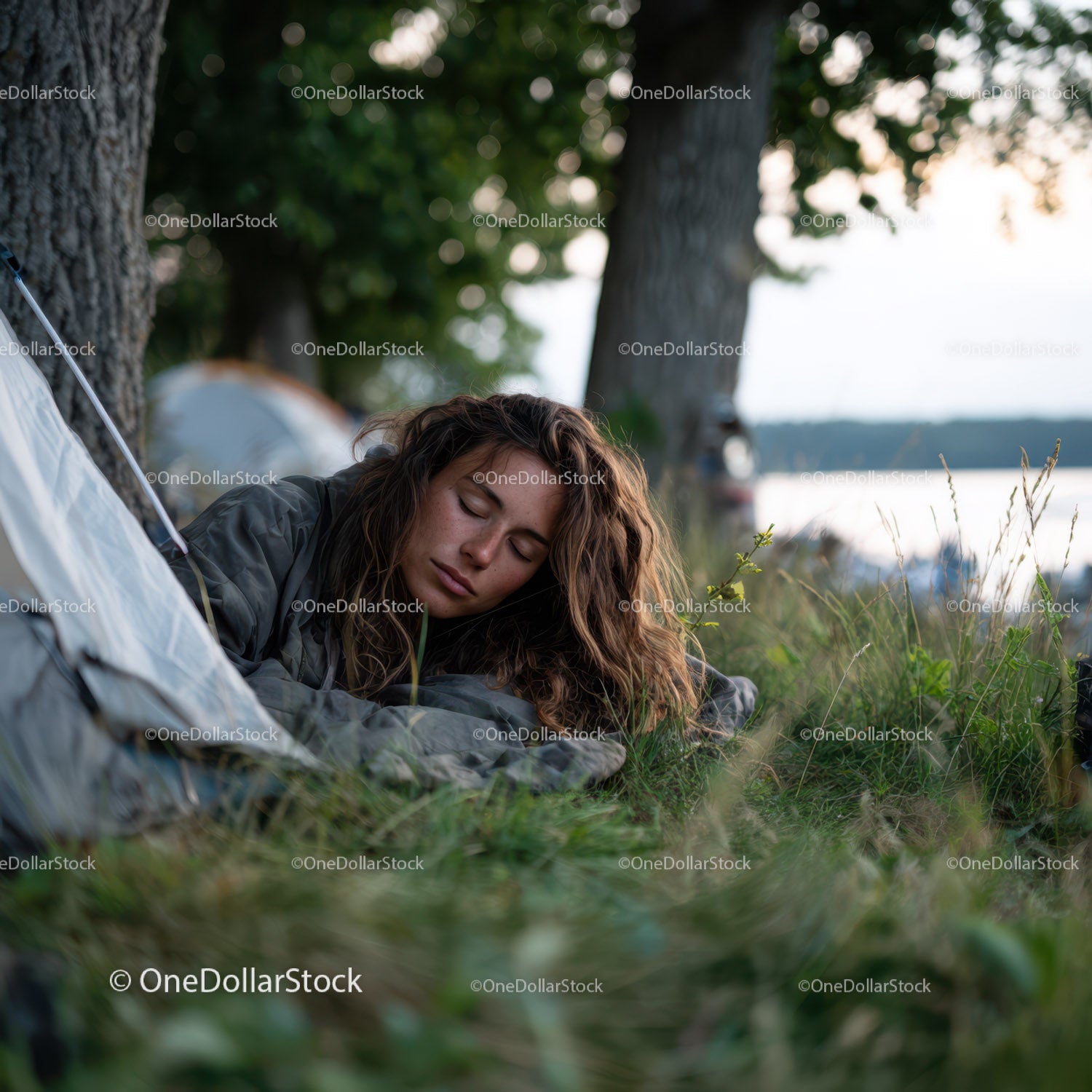 Serene Woman Resting on Grass by Lake in Outdoor Camping Scene