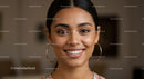Portrait of a Smiling Woman with Hoops in Bright Interior