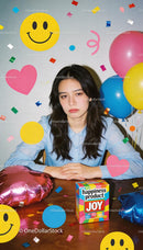 Young woman surrounded by colorful balloons and confetti