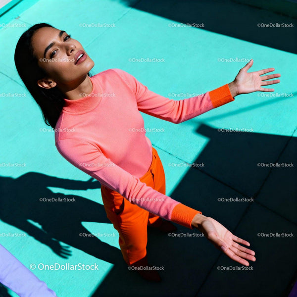 Young woman basking in sunlight with open arms