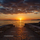 Serene Ocean Sunset with Cloudy Sky and Stone Pier