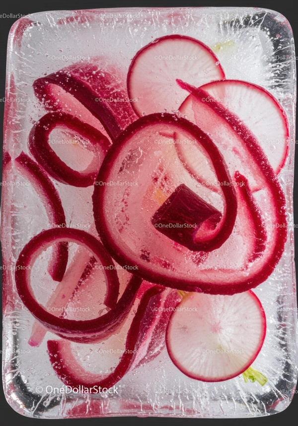Red radish slices frozen inside a clear ice block