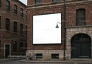 Empty square billboard on red brick building facade