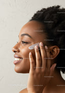 Woman applying facial moisturizer with healthy glowing skin
