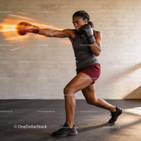 Focused female boxer throwing a powerful punch indoors