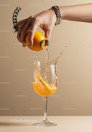 Hand Pouring Fresh Orange Juice Into Glass With Splash