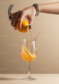 Hand Pouring Fresh Orange Juice Into Glass With Splash