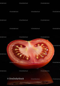 Fresh ripe tomato half on reflective black surface