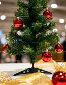 Miniature Christmas tree decorated with red baubles