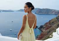 Elegant woman in yellow dress overlooking sea cliff