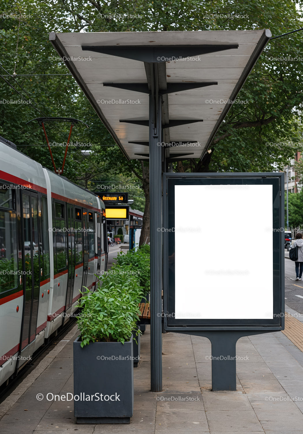 Modern tram stop with green plants and blank advertising board