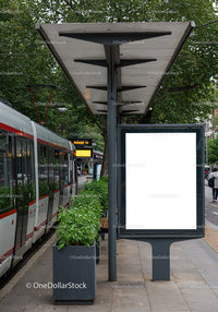 Modern tram stop with green plants and blank advertising board