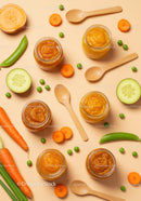 Assorted vegetable purees in jars with fresh produce