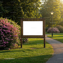 Empty wooden signboard in sunny park with blooming bushes
