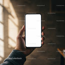 Hand Holding Smartphone with Blank White Screen in Warm Light