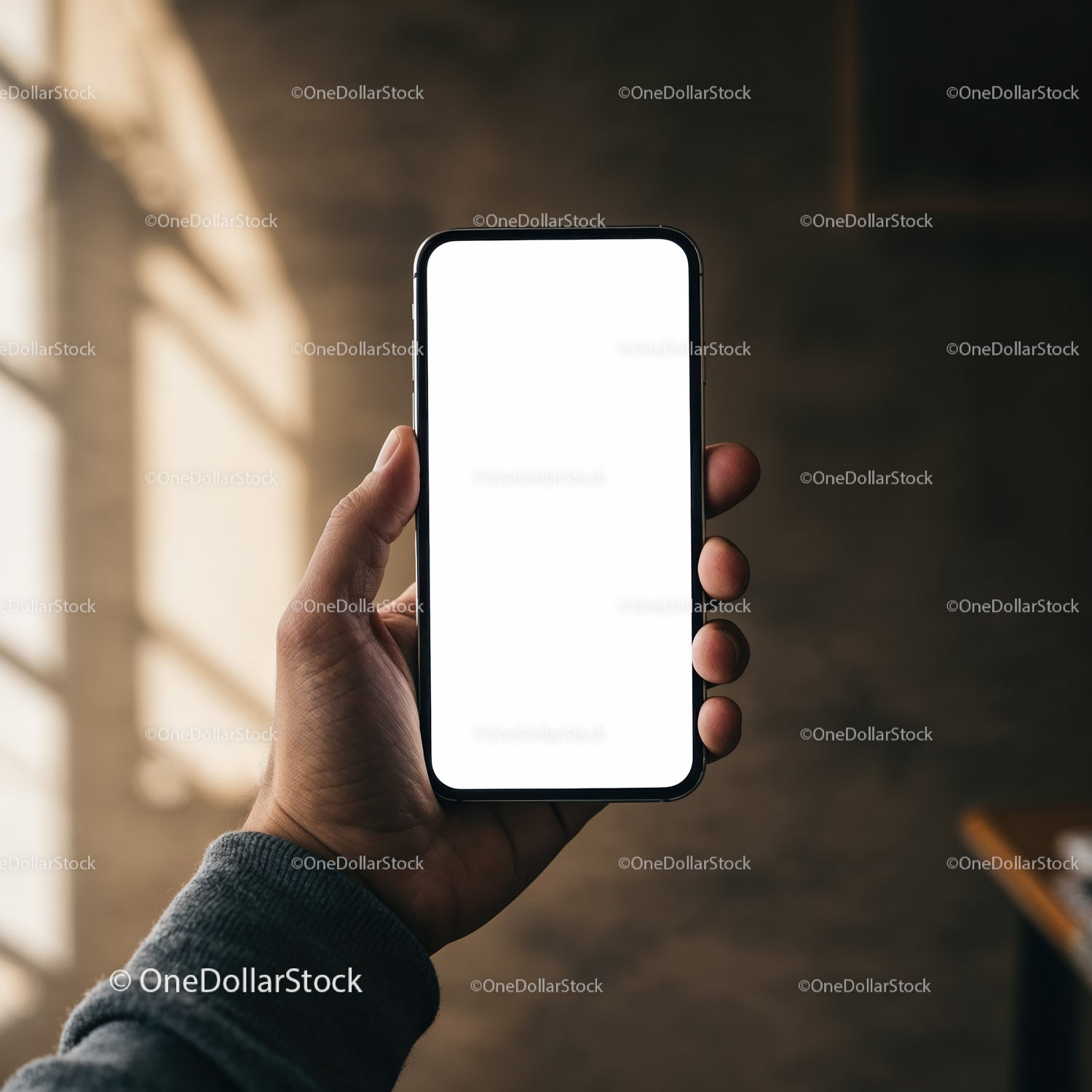 Ręka trzymająca smartfon z pustym, białym ekranem w ciepłym świetle