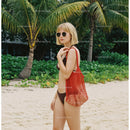 Woman in Bikini with Red Tote Bag on Tropical Beach with Palm Trees